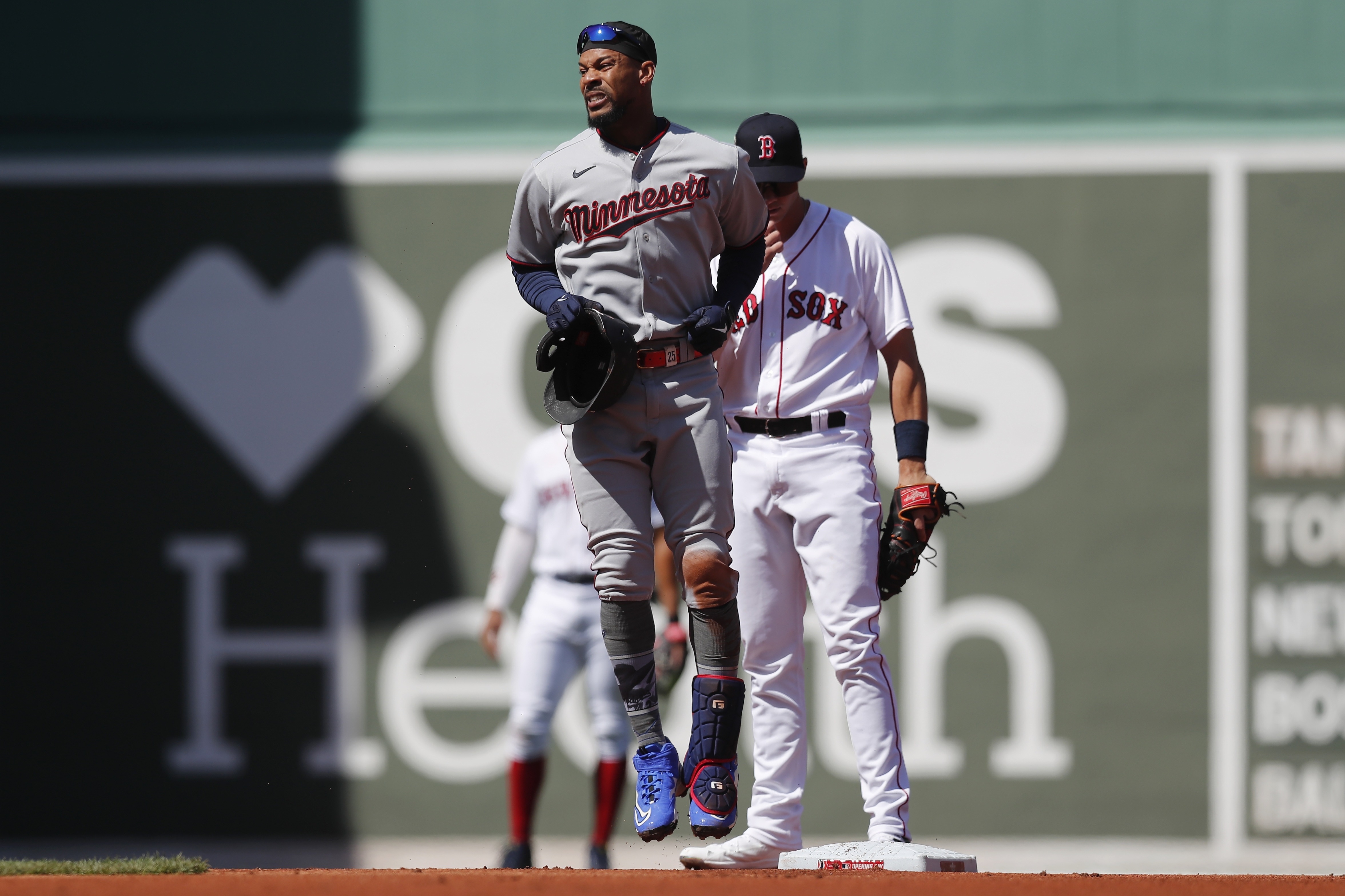 Minnesota Twins' Byron Buxton, front, reacts after being injured on his double during the first inning of a baseball game against the Boston Red Sox, Friday, April 15, 2022, in Boston. Buxton was replaced in the game by Nick Gordon.