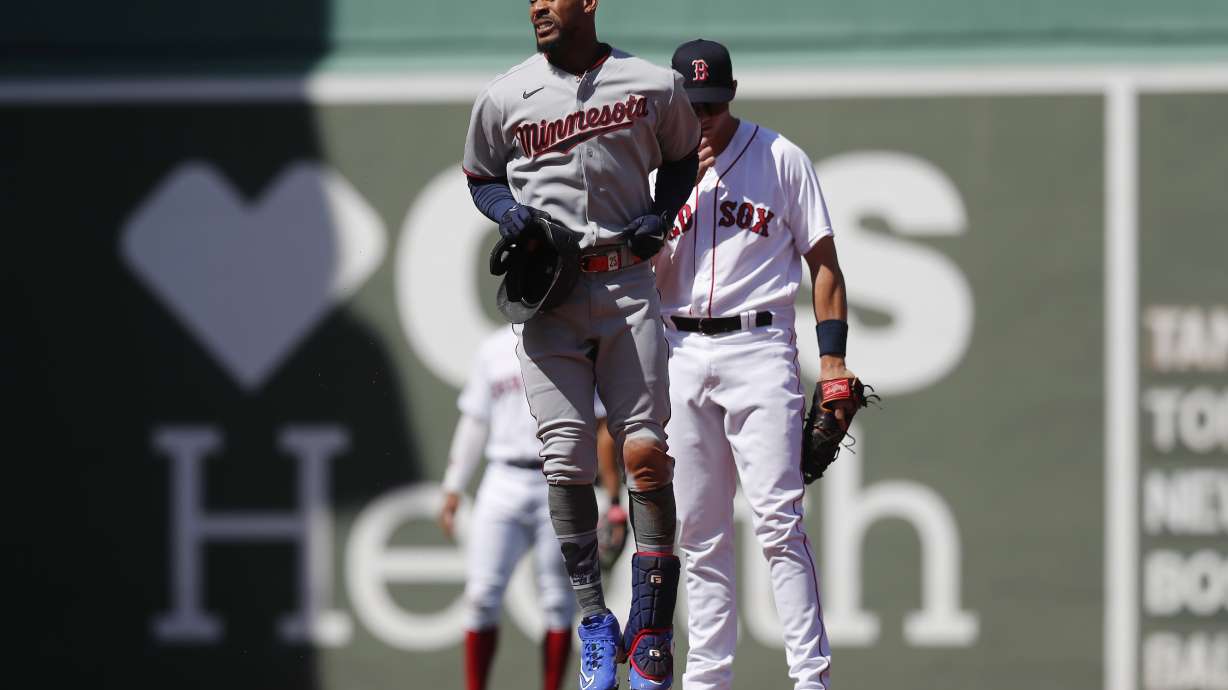 Minnesota Twins' Byron Buxton, front, reacts after being injured on his double during the first inning of a baseball game against the Boston Red Sox, Friday, April 15, 2022, in Boston. Buxton was replaced in the game by Nick Gordon.