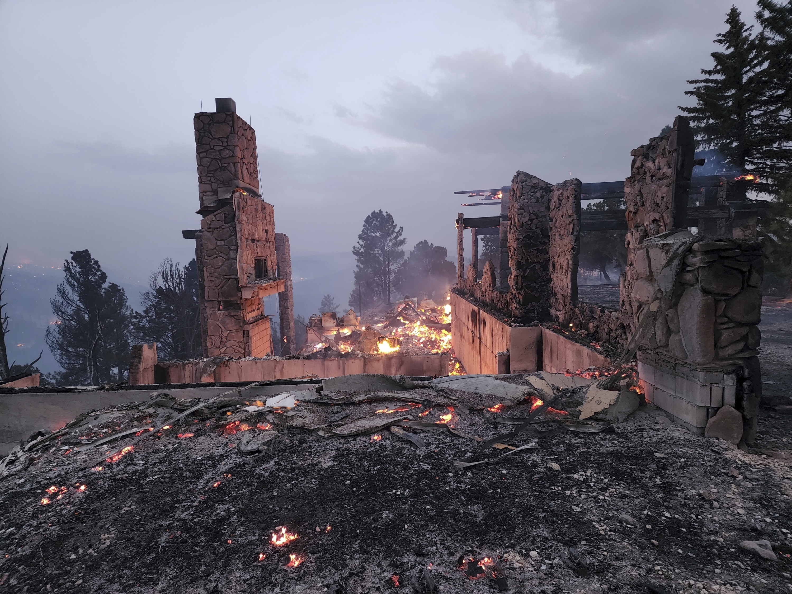 The remains of a home left after a wildfire spread through the Village of Ruidoso, New Mexico, on Wednesday. Officials say a wildfire has burned about 150 structures, including homes, in the New Mexico town of Ruidoso.