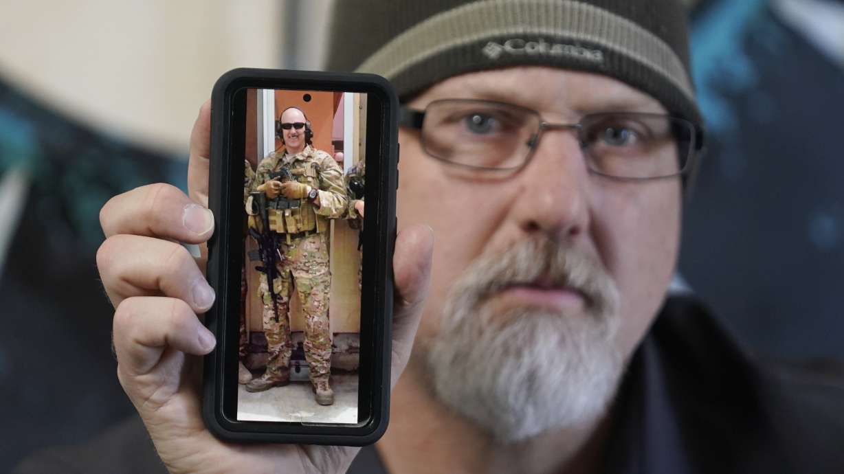 Matthew Butler, who spent 27 years in the Army, holds a 2014 photograph of himself during his last deployment in Kabul Afghanistan, on March 30, in Sandy.