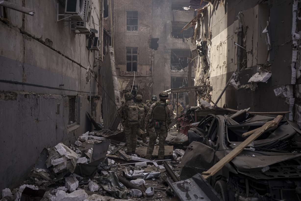 Ukrainian servicemen walk among debris of damaged buildings after a Russian attack in Kharkiv, Ukraine, Saturday.