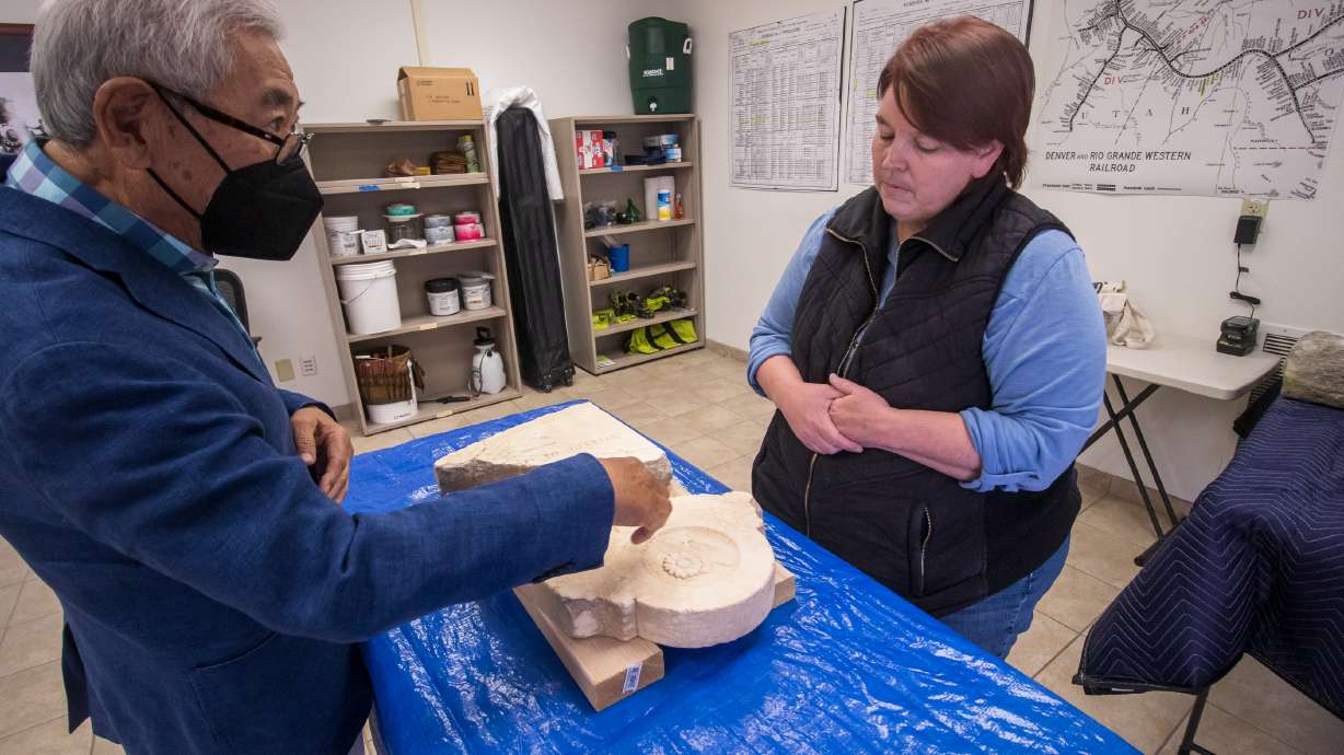 Floyd Mori points to details he notices in a tombstone to Amy Barry before Barry begins cleaning it Saturday morning. The tombstone remembers K. Kawanishi, a Japanese-born railroad worker who appears to have died in southeast Utah in the early 1900s.