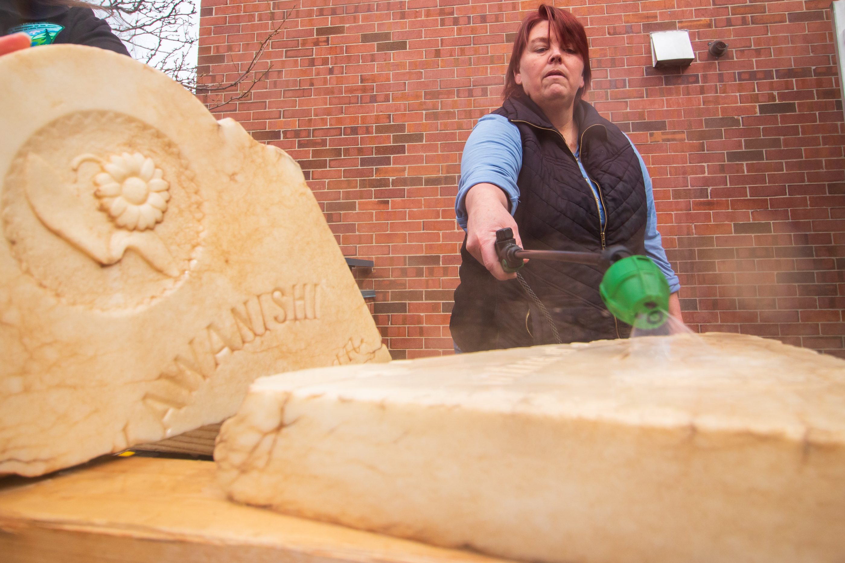 Amy Barry, cemeteries program manager for the Utah Division of State History, cleans K. Kawanishi's tombstone Saturday morning. Kawanishi is buried in a remote part of Grand County.