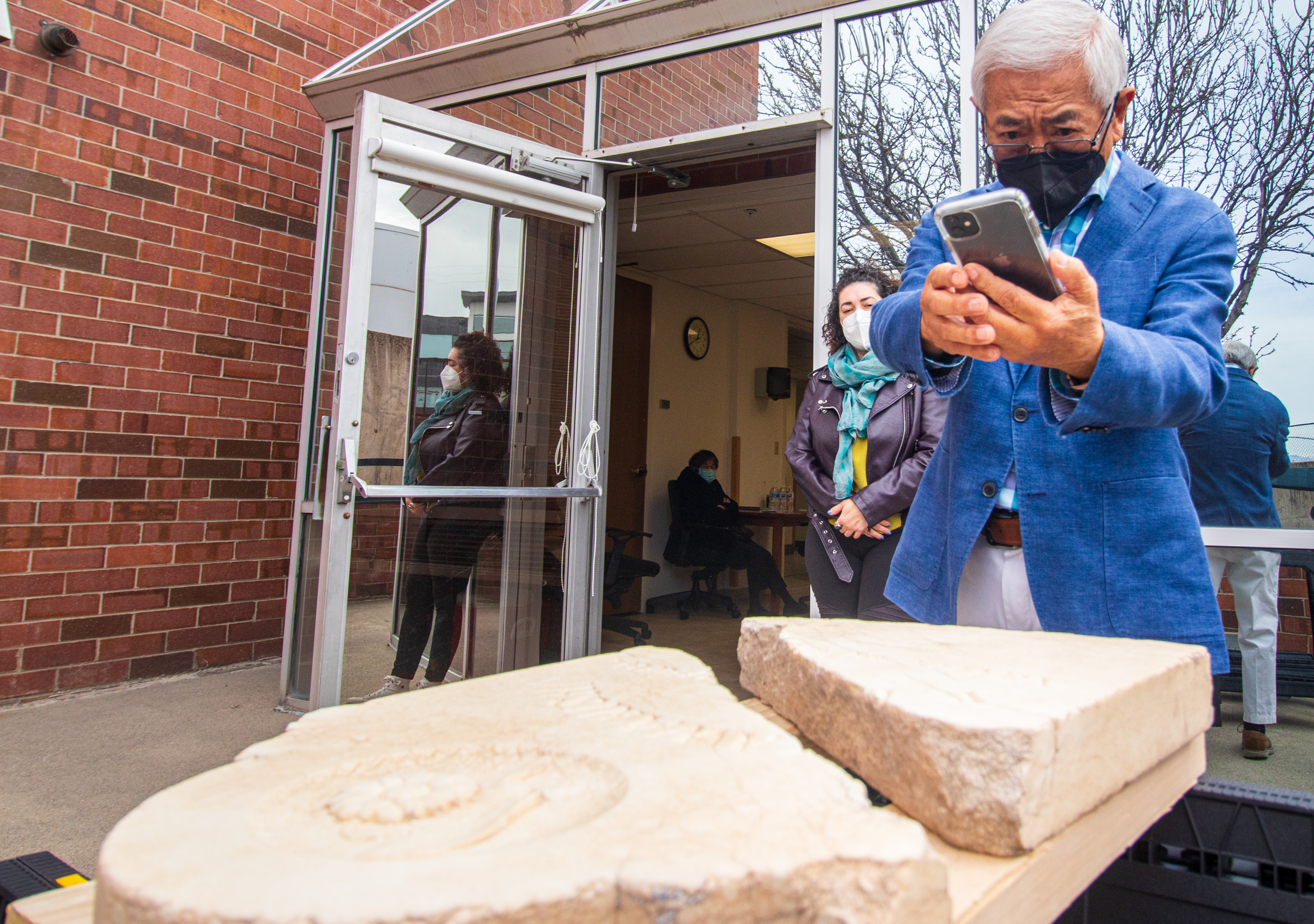 Floyd Mori takes a photo of K. Kawanishi's tombstone before it's cleaned Saturday morning.