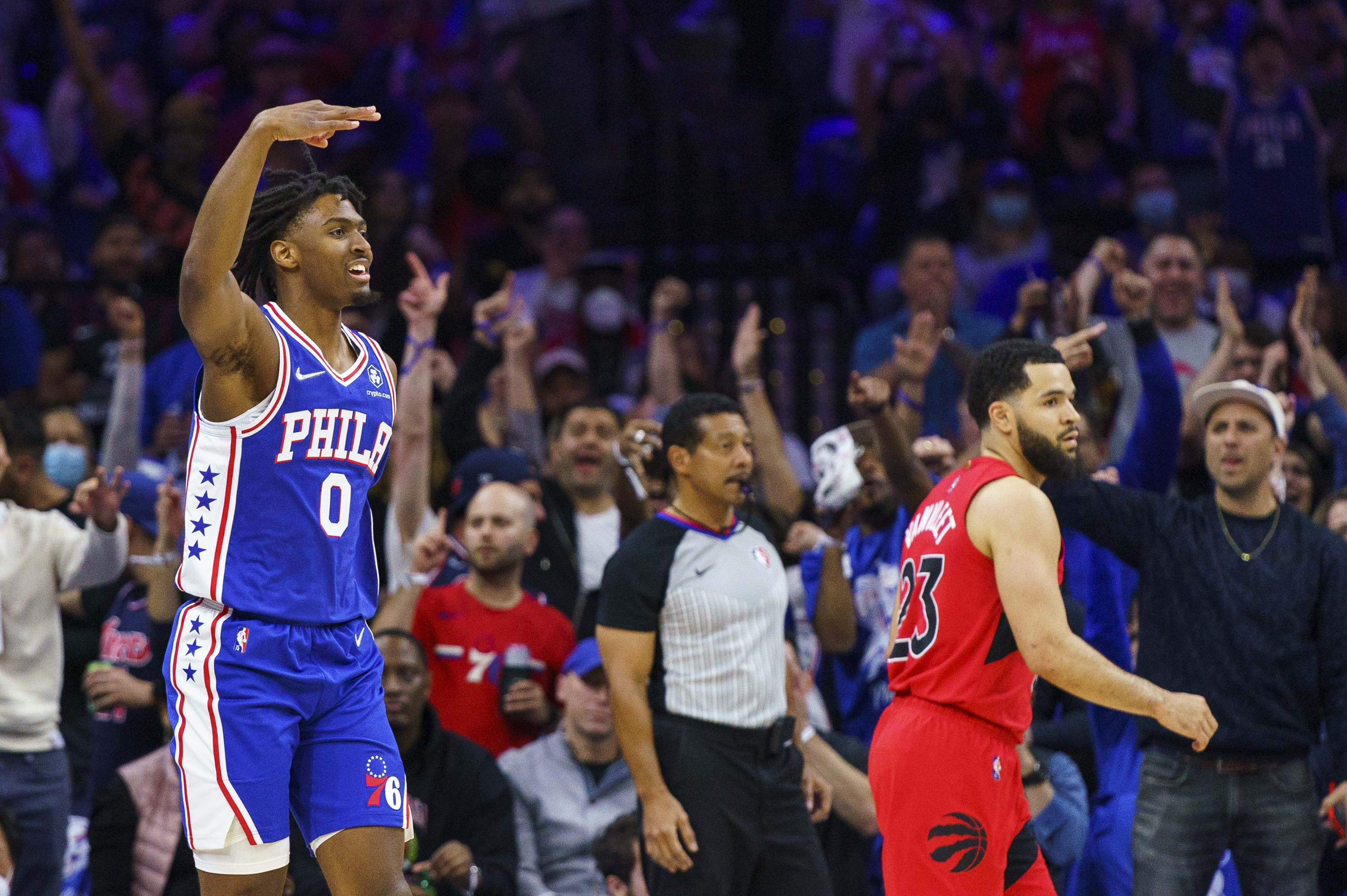 Philadelphia 76ers' Tyrese Maxey, left, reacts to his three-pointer as Toronto Raptors' Fred VanVleet, right, looks on during the first half of Game 1 of an NBA basketball first-round playoff series, Saturday, April 16, 2022, in Philadelphia. 