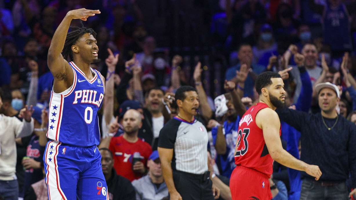 Philadelphia 76ers' Tyrese Maxey, left, reacts to his three-pointer as Toronto Raptors' Fred VanVleet, right, looks on during the first half of Game 1 of an NBA basketball first-round playoff series, Saturday, April 16, 2022, in Philadelphia.