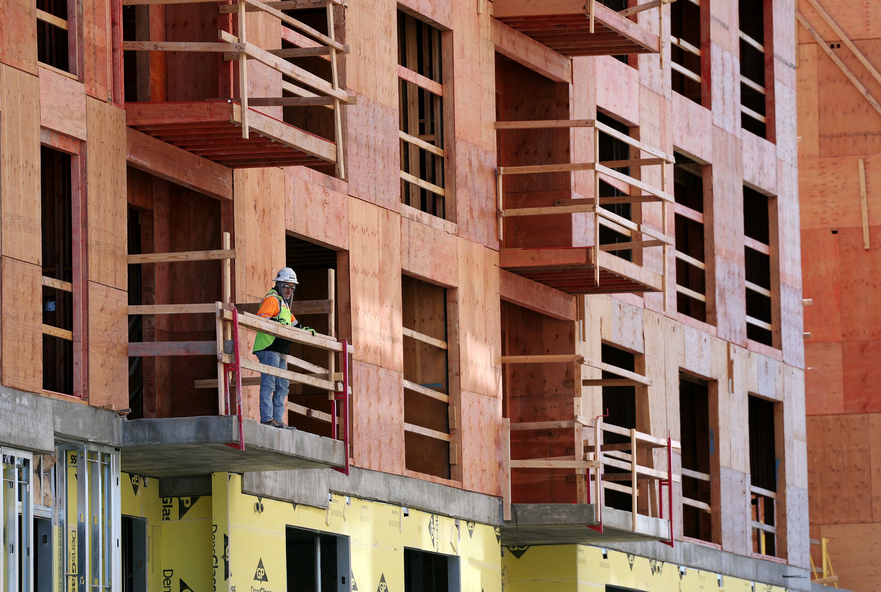 A worker stands on a balcony at a construction site in Salt Lake City on Wednesday, April 6.