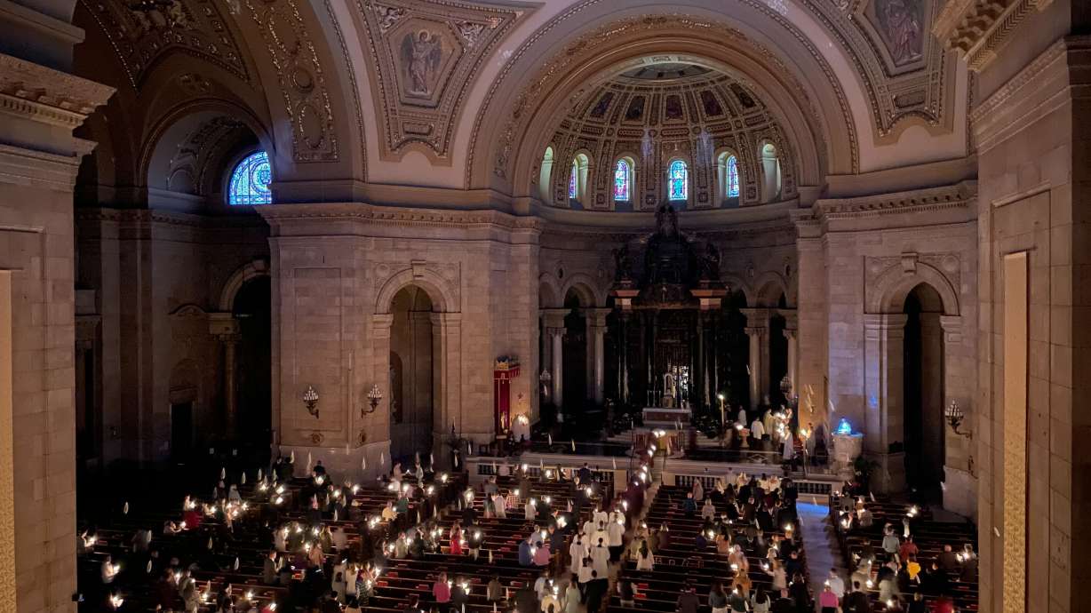Hundreds of people light candles at the beginning of the Easter Vigil Mass at the Cathedral of St. Paul in St. Paul, Minn., on Saturday. For many U.S. Christians, this weekend marks the first time since 2019 that they will gather in person on Easter Sunday, a welcome chance to celebrate one of the year's holiest days side by side with fellow congregants.