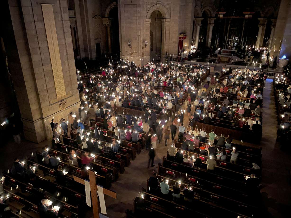 Hundreds of people light candles at the beginning of the Easter Vigil Mass at the Cathedral of St. Paul in St. Paul, Minn., on Saturday. For many U.S. Christians, this weekend marks the first time since 2019 that they will gather in person on Easter Sunday, a welcome chance to celebrate one of the year's holiest days side by side with fellow congregants.