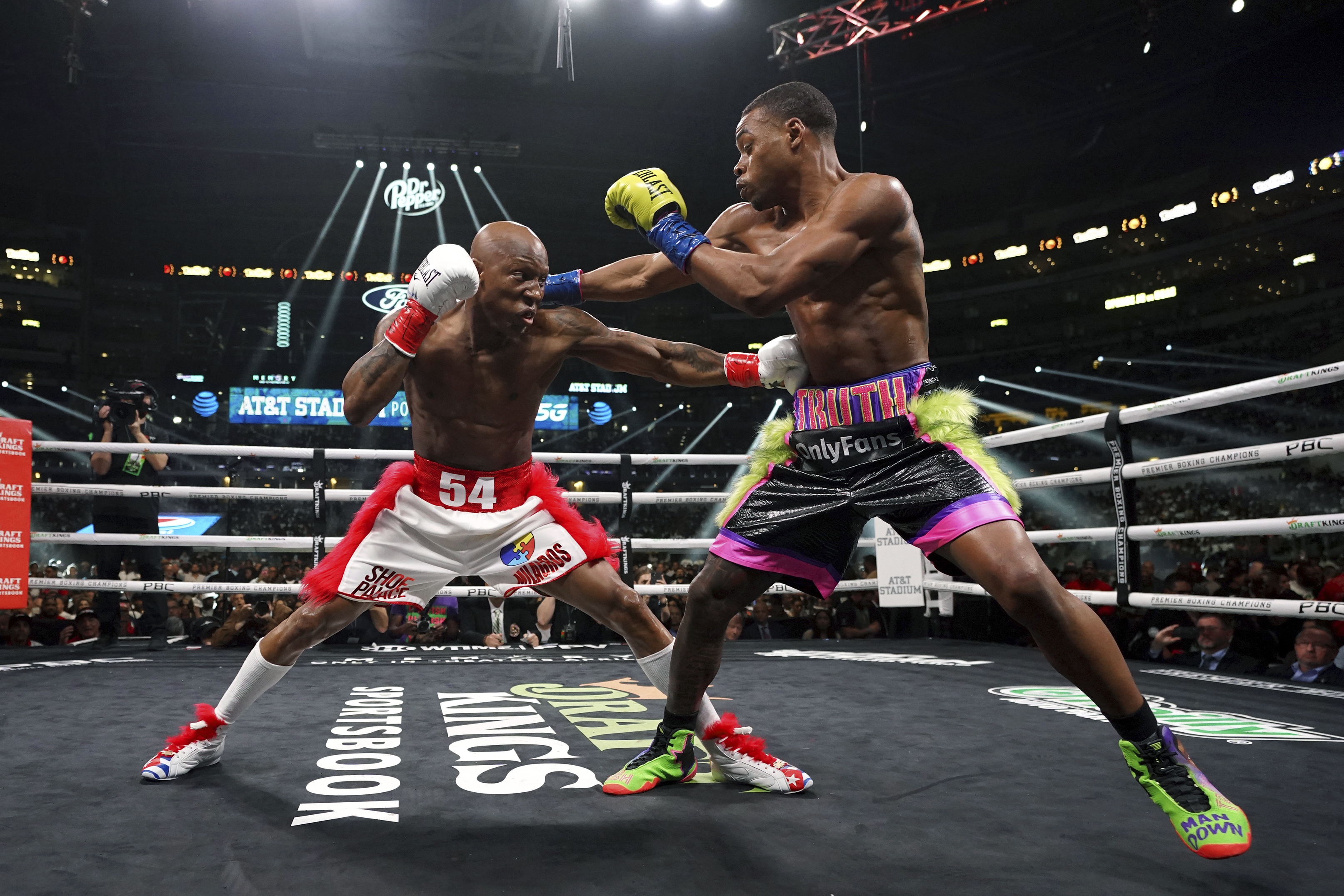 Errol Spence Jr., right, and Yordenis Ugas, from Cuba, trade punches during a welterweight championship boxing match Saturday, April 16, 2022, in Arlington, Texas. 