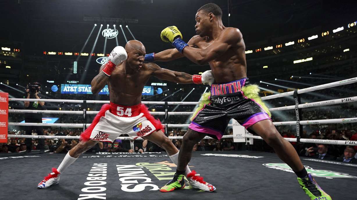 Errol Spence Jr., right, and Yordenis Ugas, from Cuba, trade punches during a welterweight championship boxing match Saturday, April 16, 2022, in Arlington, Texas.