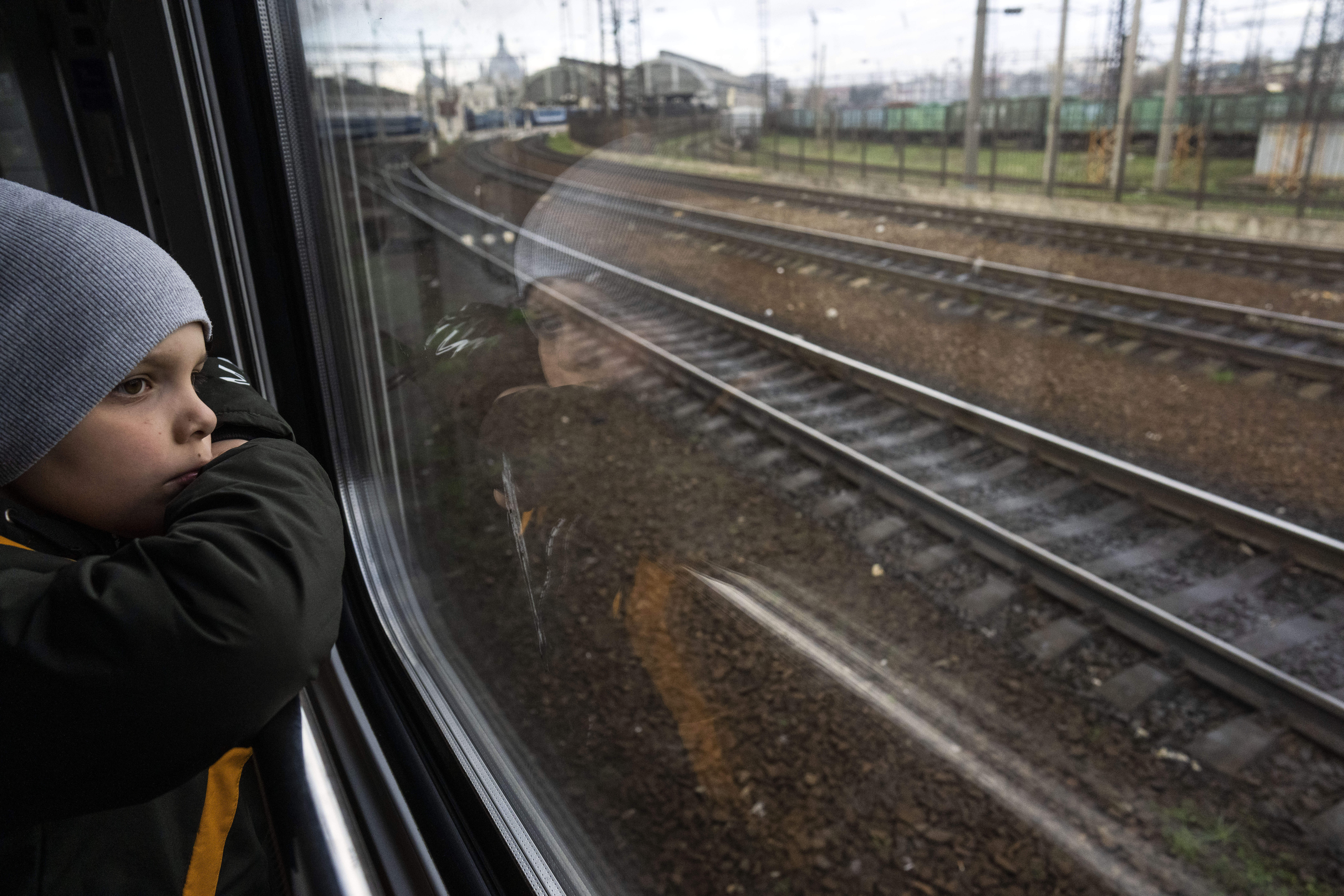 Sergei looks out of the window of a train minutes before arriving with his family in Lviv, from Kyiv, Ukraine, Sunday.