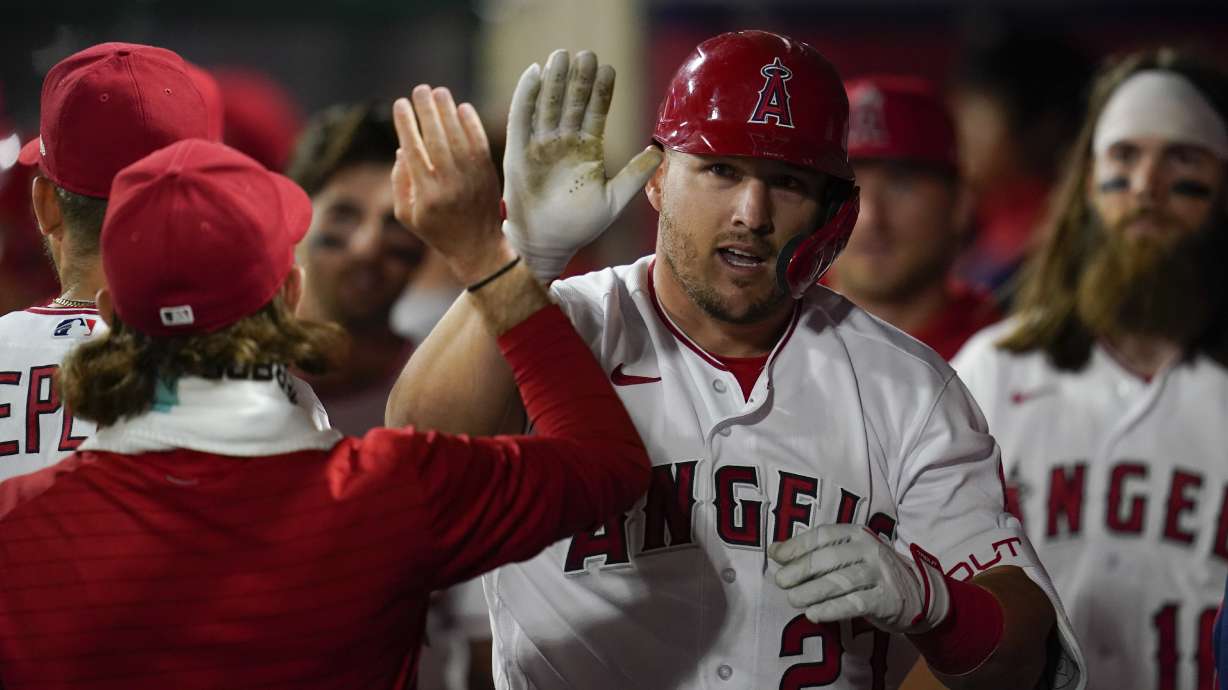 Los Angeles Angels center fielder Mike Trout (27) celebrates in the dugout after hitting a homerun during the seventh inning of a baseball game against the Houston Astros in Anaheim, Calif., Saturday, April 9, 2022.