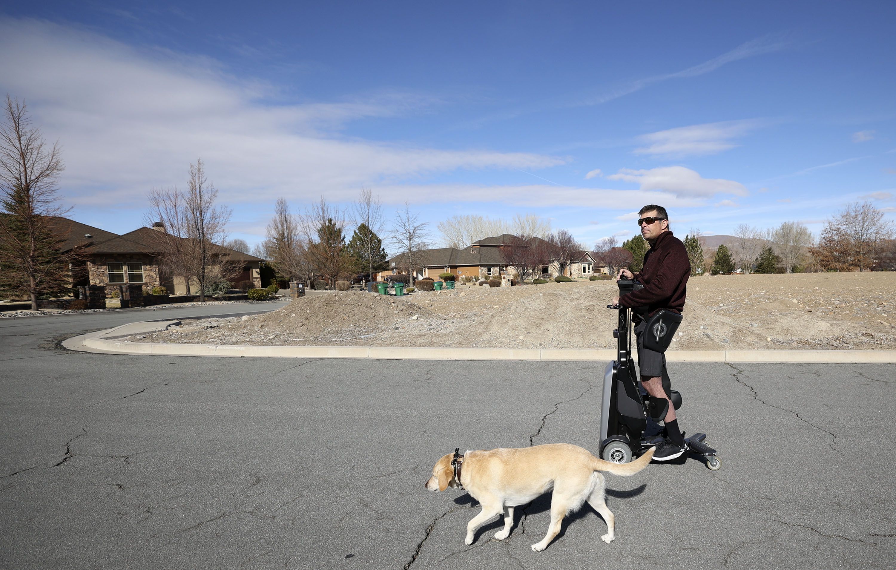 Bill Winchester uses his Tek RMD to go to his in-laws’ house down the street with his dog Remi in Reno, Nevada, on Monday, March 21.