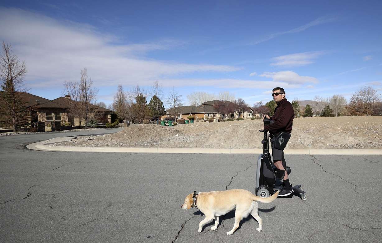 Bill Winchester uses his Tek RMD to go to his in-laws’ house down the street with his dog Remi in Reno, Nevada, on Monday, March 21.