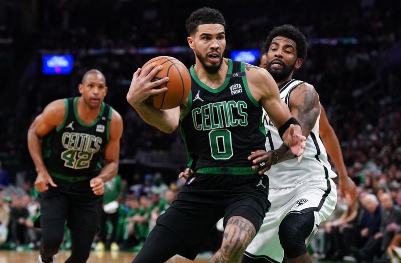 Apr 17, 2022; Boston, Massachusetts, USA; Boston Celtics forward Jayson Tatum (0) drives the ball against Brooklyn Nets guard Kyrie Irving (11) in the second half during game one of the first round for the 2022 NBA playoffs at TD Garden.
