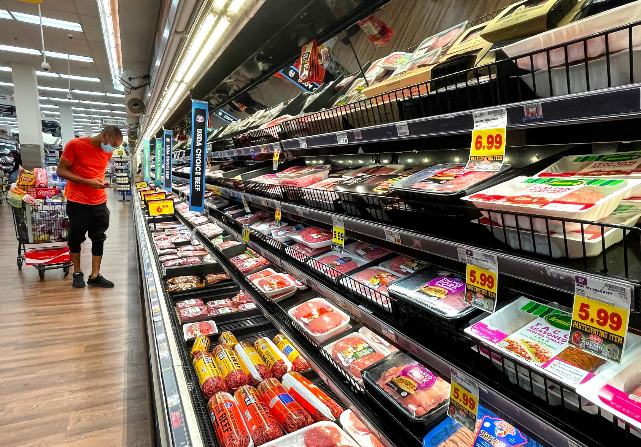 A person shops in the meat section of a grocery store on Nov. 11, 2021, in Los Angeles. Consumers around the world are paying more for goods and services.