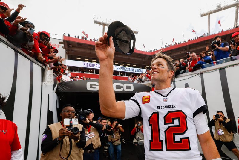 FILE PHOTO: Jan 16, 2022; Tampa, Florida, USA; Tampa Bay Buccaneers quarterback Tom Brady (12) greets fans after beating the Philadelphia Eagles 31-15 in a NFC Wild Card playoff football game at Raymond James Stadium.