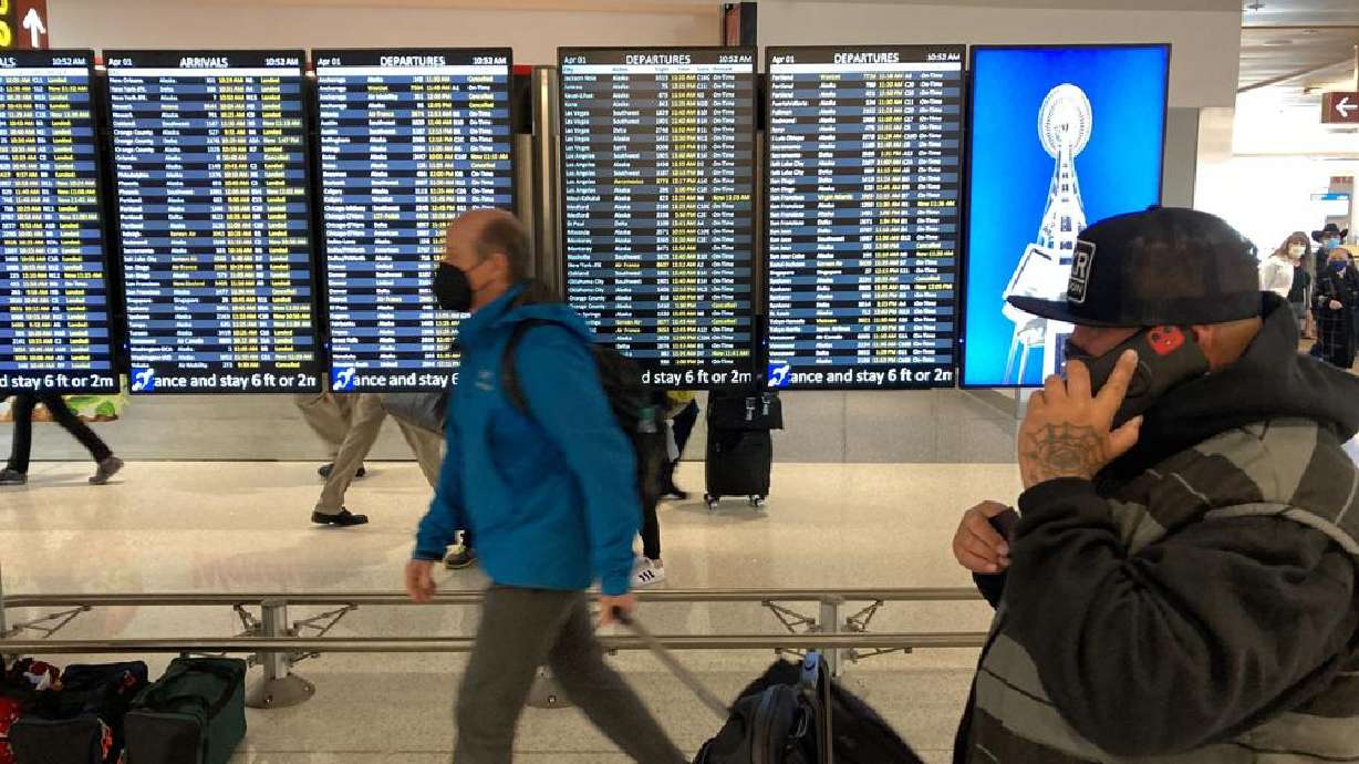 Travelers walk through Seattle-Tacoma International Airport on April 1 in Seattle. On Monday, a federal judge in Florida voided the national mask mandate covering airplanes and other public transportation saying it exceeded the authority of U.S. health officials.