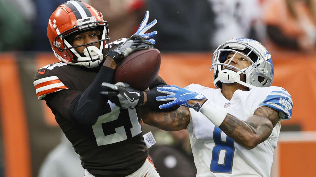 FILE - Cleveland Browns cornerback Denzel Ward (21) intercepts a pass intended for Detroit Lions wide receiver Josh Reynolds (8) during the second half of an NFL football game, Sunday, Nov. 21, 2021, in Cleveland. Cleveland Browns Pro Bowl cornerback Denzel Ward has agreed to a five-year, $100.5 million contract extension with the team, a person familiar with the negotiations told The Associated Press on Monday, April 18, 2022.