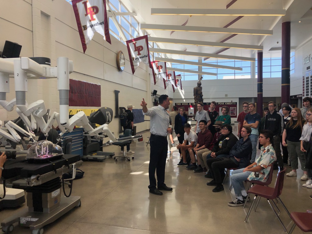 Tommy Lalli, clinical sales representative for Intuitive, prepares students to operate the da Vinci XI robotic-assisted surgical system at Lone Peak High School on Monday. 