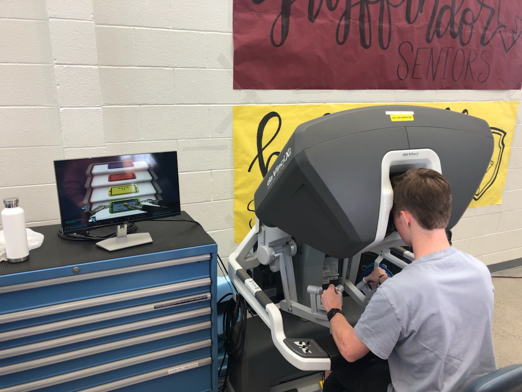 A Lone Peak High School student gets his turn at operating the da Vinci XI robotic-assisted surgical system at Lone Peak High School on Monday.