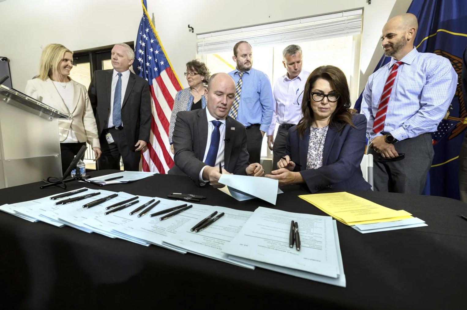 Gov. Spencer Cox and Lt. Governor Deidre Henderson ceremonially sign key water legislation at Jordanelle Reservoir in Wasatch County on Monday.
