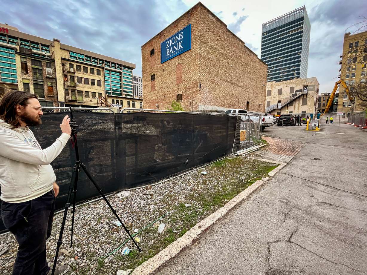 Michael Valentine records on his phone as crews begin demolition of an old parking garage next to the Utah Pantages Theater Tuesday morning. The demolition began a day after a judge struck down a temporary restraining order to protect the theater.