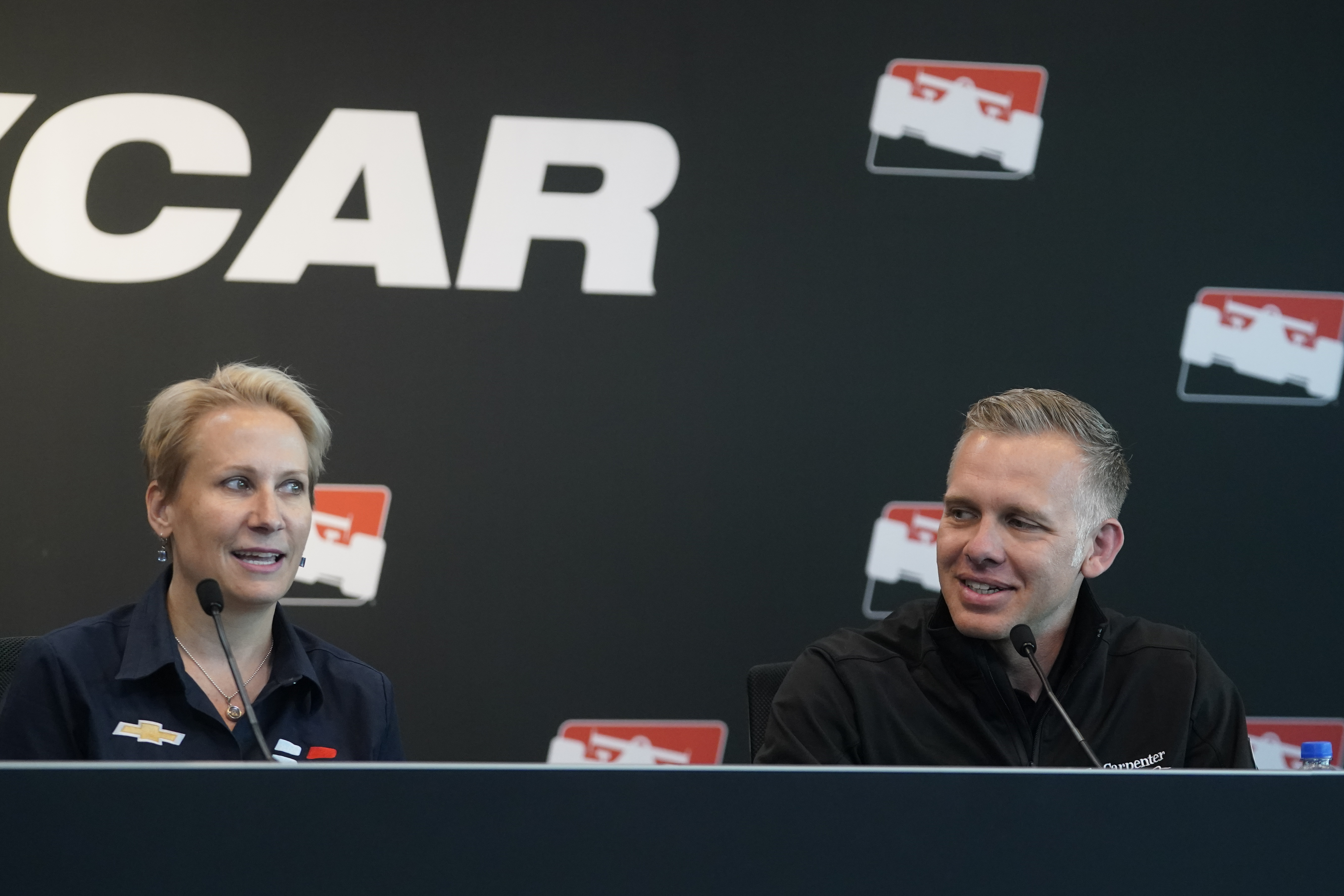 Beth Paretta, left, Team Principal, Paretta Autosport, speaks during a news conference at the Indianapolis Motor Speedway as Ed Carpenter listens, Tuesday, April 19, 2022, in Indianapolis. Paretta, announced today at the Indianapolis Motor Speedway that Paretta Autosport will return to the NTT INDYCAR Series to campaign in multiple races in 2022. 