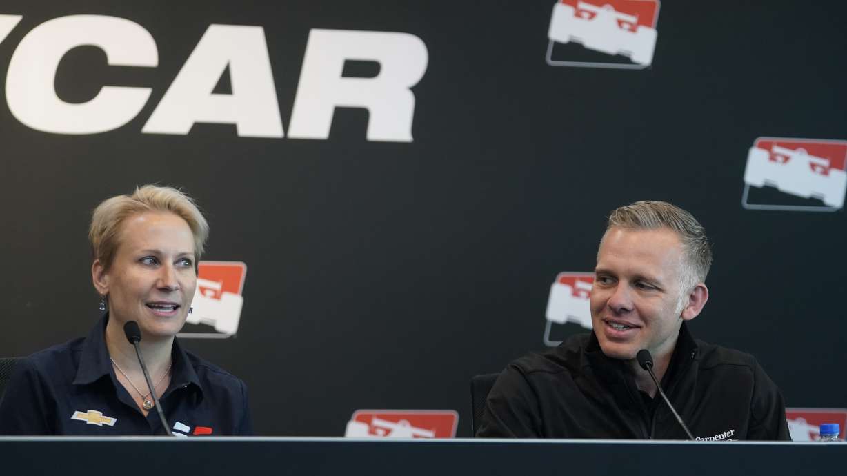 Beth Paretta, left, Team Principal, Paretta Autosport, speaks during a news conference at the Indianapolis Motor Speedway as Ed Carpenter listens, Tuesday, April 19, 2022, in Indianapolis. Paretta, announced today at the Indianapolis Motor Speedway that Paretta Autosport will return to the NTT INDYCAR Series to campaign in multiple races in 2022.