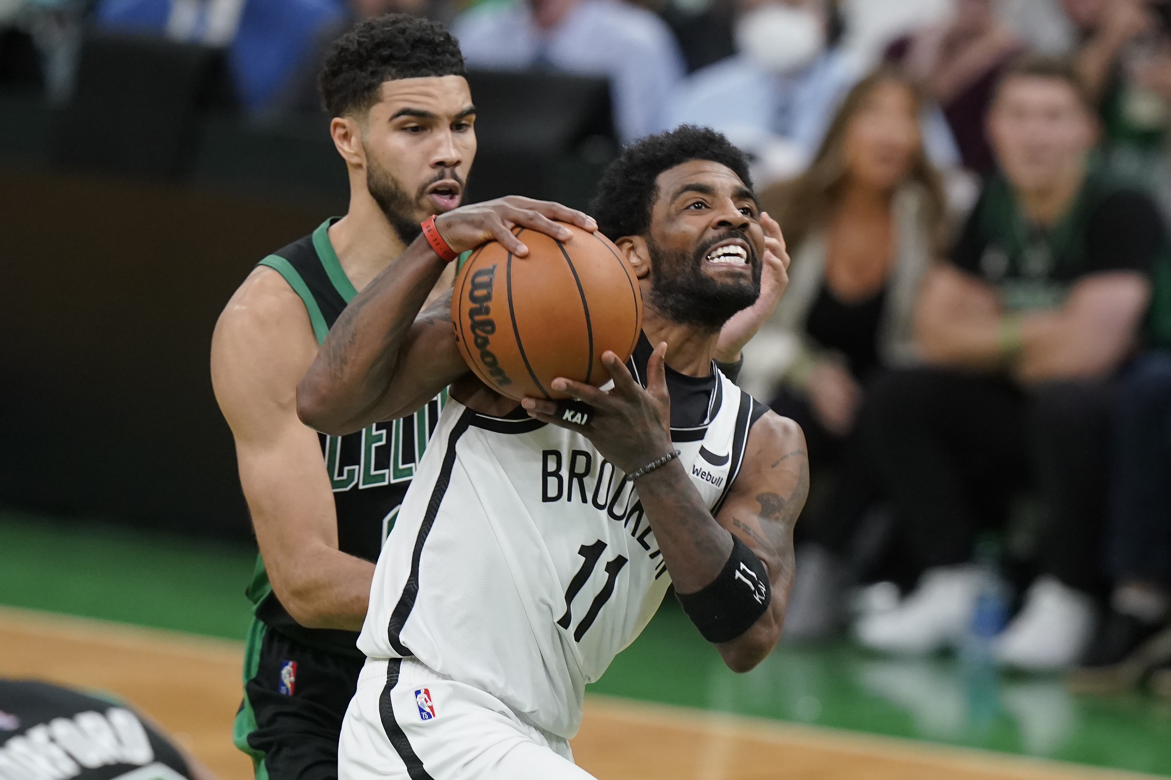 Brooklyn Nets guard Kyrie Irving (11) drives toward the basket as Boston Celtics forward Jayson Tatum (0) defends in the second half of Game 1 of an NBA basketball first-round Eastern Conference playoff series, Sunday, April 17, 2022, in Boston. The Celtics won 115-114. 