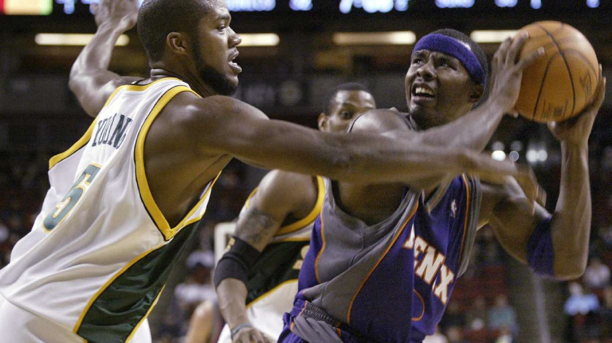 FILE - Seattle SuperSonics' Galen Young (5) guards Phoenix Suns' Quentin Richardson during the first half of a preseason basketball game Saturday, Oct. 16, 2004, in Seattle. A woman who crashed her car into a Memphis house has been charged with vehicular homicide in the death of Galen Young, a former college and pro basketball player found dead in the home, prosecutors said Tuesday, April 19, 2022.
