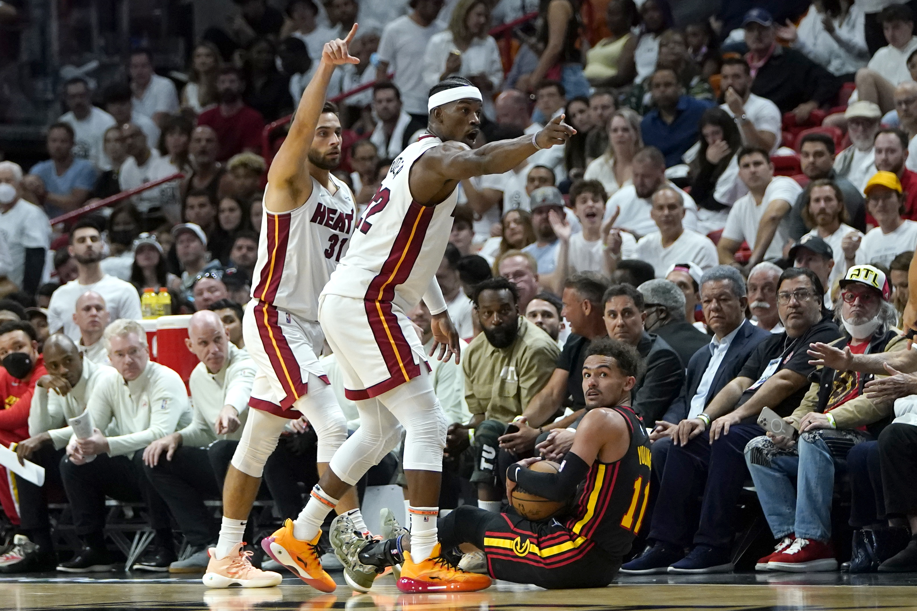 Miami Heat guard Max Strus, left, and forward Jimmy Butler (22) motion down the court for a Heat possession and Atlanta Hawks guard Trae Young loses control of the ball during the first half of Game 2 of an NBA basketball first-round playoff series, Tuesday, April 19, 2022, in Miami. 