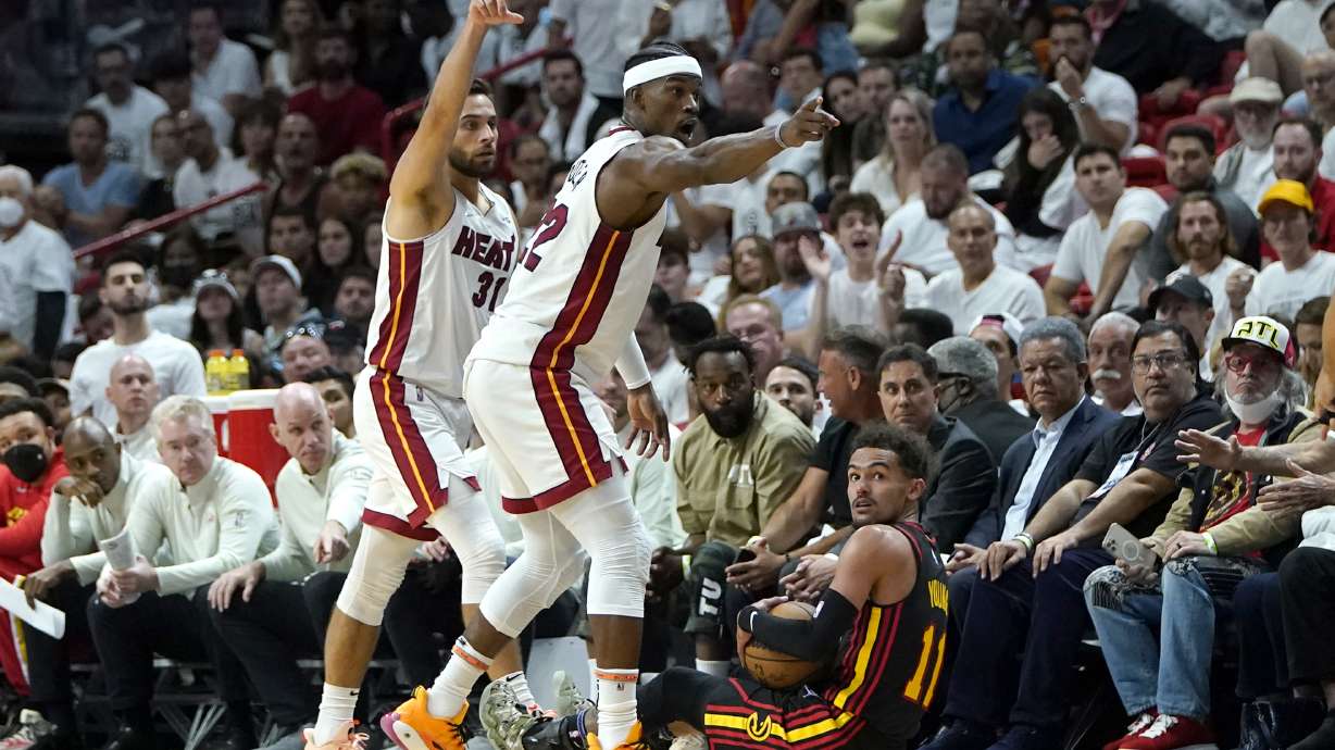 Miami Heat guard Max Strus, left, and forward Jimmy Butler (22) motion down the court for a Heat possession and Atlanta Hawks guard Trae Young loses control of the ball during the first half of Game 2 of an NBA basketball first-round playoff series, Tuesday, April 19, 2022, in Miami.