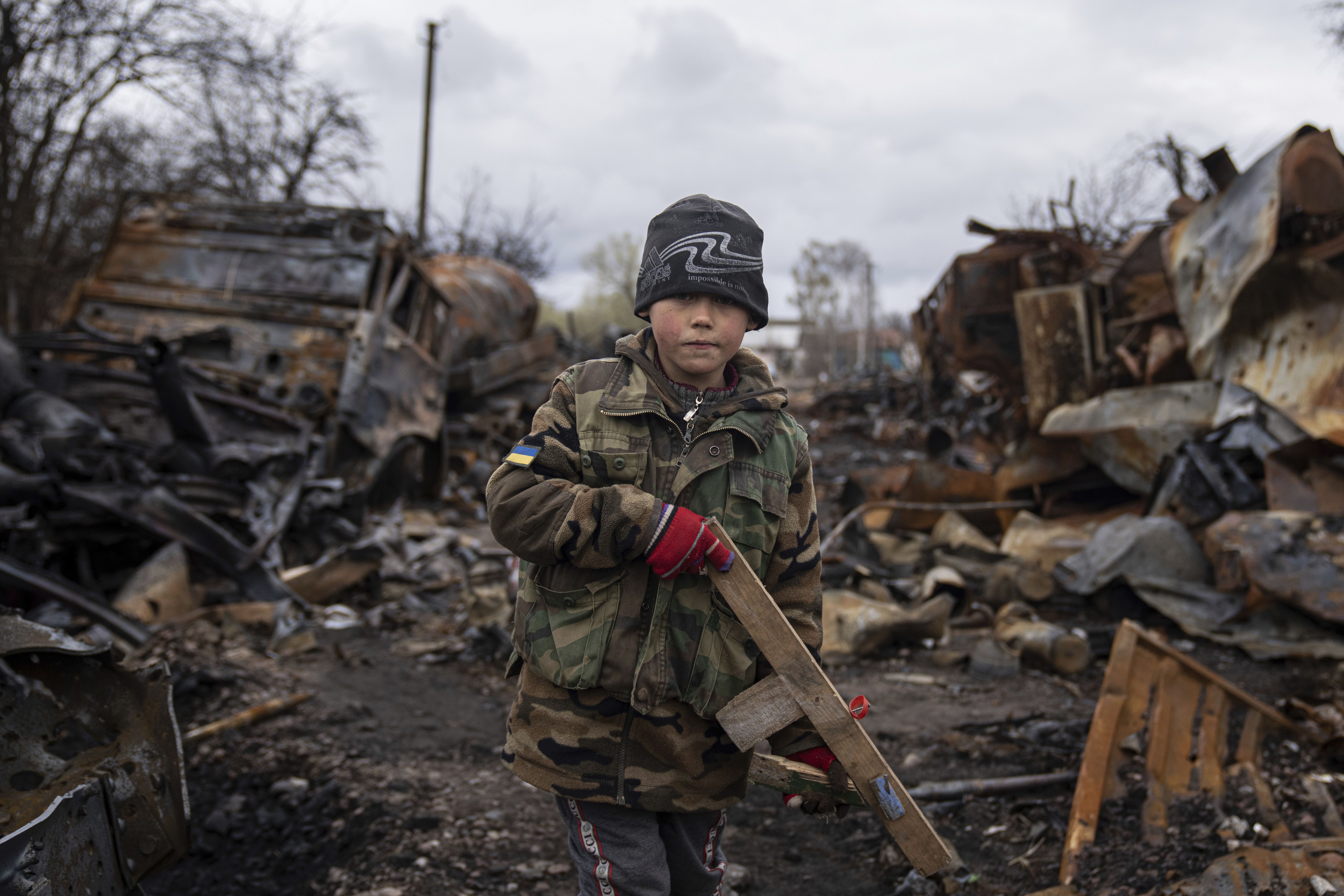 Yehor, 7, stands holding a wooden toy rifle next to destroyed Russian military vehicles near Chernihiv, Ukraine, Sunday. Witnesses said multiple explosions believed to be caused by missiles struck the western Ukrainian city of Lviv early Monday as the country was bracing for an all-out Russian assault in the east.