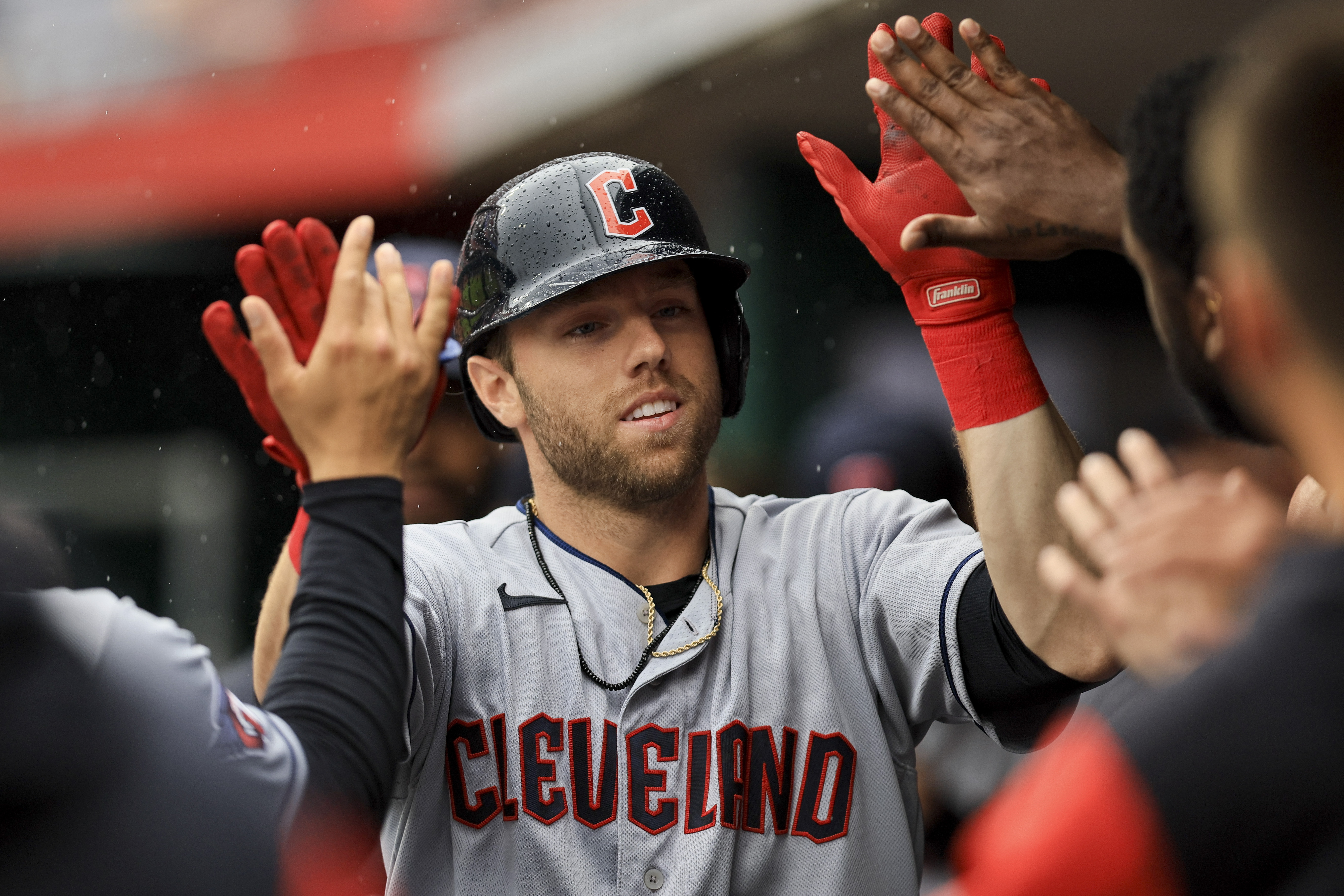 Cleveland Guardians' Owen Miller high-fives teammates after hitting a solo home run during the eighth inning of a baseball game against the Cincinnati Reds in Cincinnati, Wednesday, April 13, 2022. The Guardians won 7-3. 