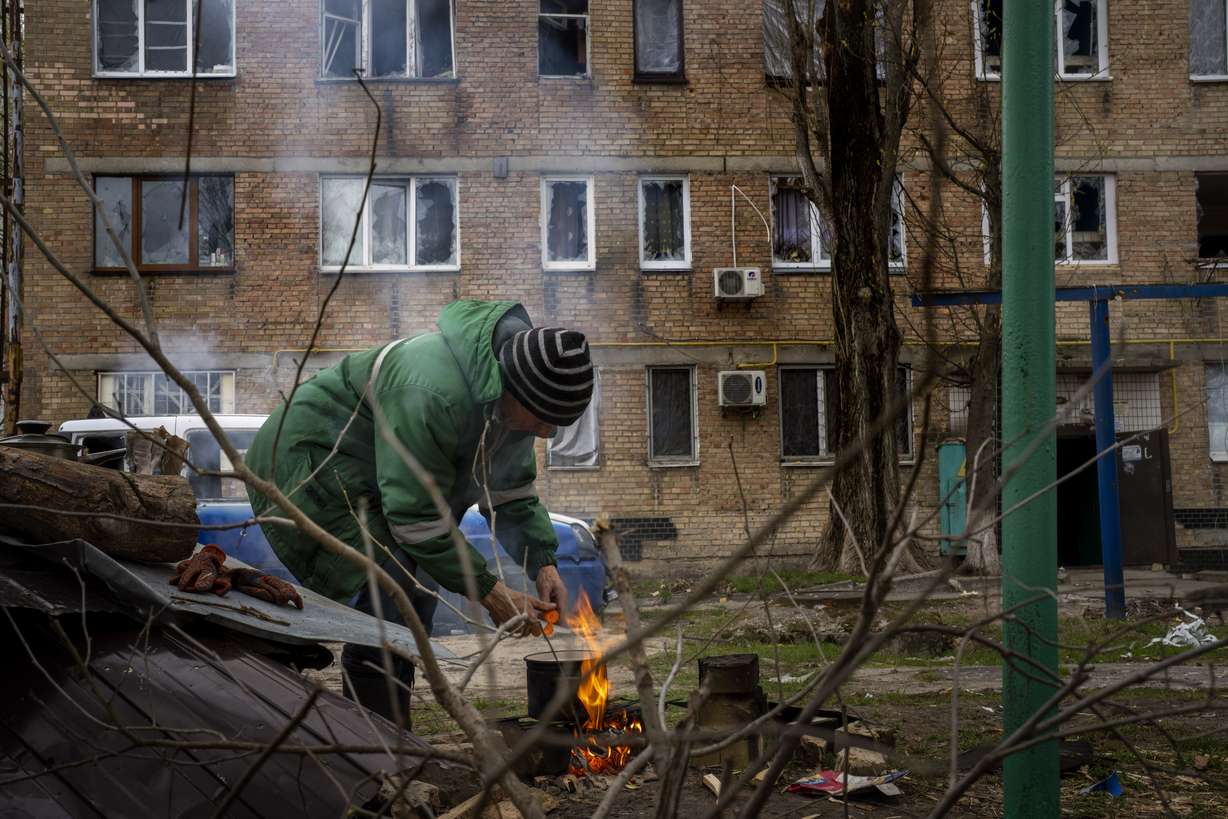 Volodymyr Lukyanovych, 63, cooks his dinner outside his house since his building was destroyed by Russian shelling in Irpin, on the outskirts of Kyiv, on Wednesday. Citizens of Irpin are still without electricity, water and gas after since the Russian invasion began.
