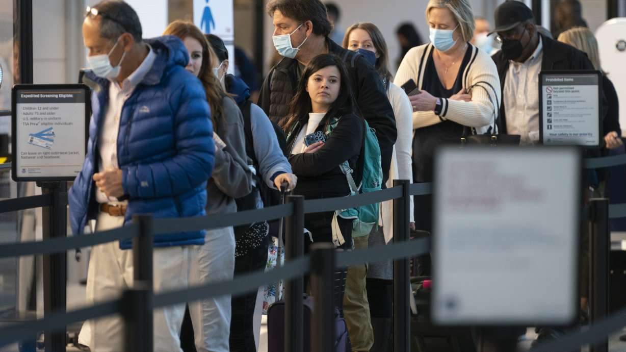 Passengers wait in line at the security checkpoint at Ronald Reagan Washington National Airport, Tuesday, in Arlington, Va. A federal judge's decision to strike down a national mask mandate was met with cheers on some airplanes but also concern about whether it's really time to end the order sparked by the COVID-19 pandemic.