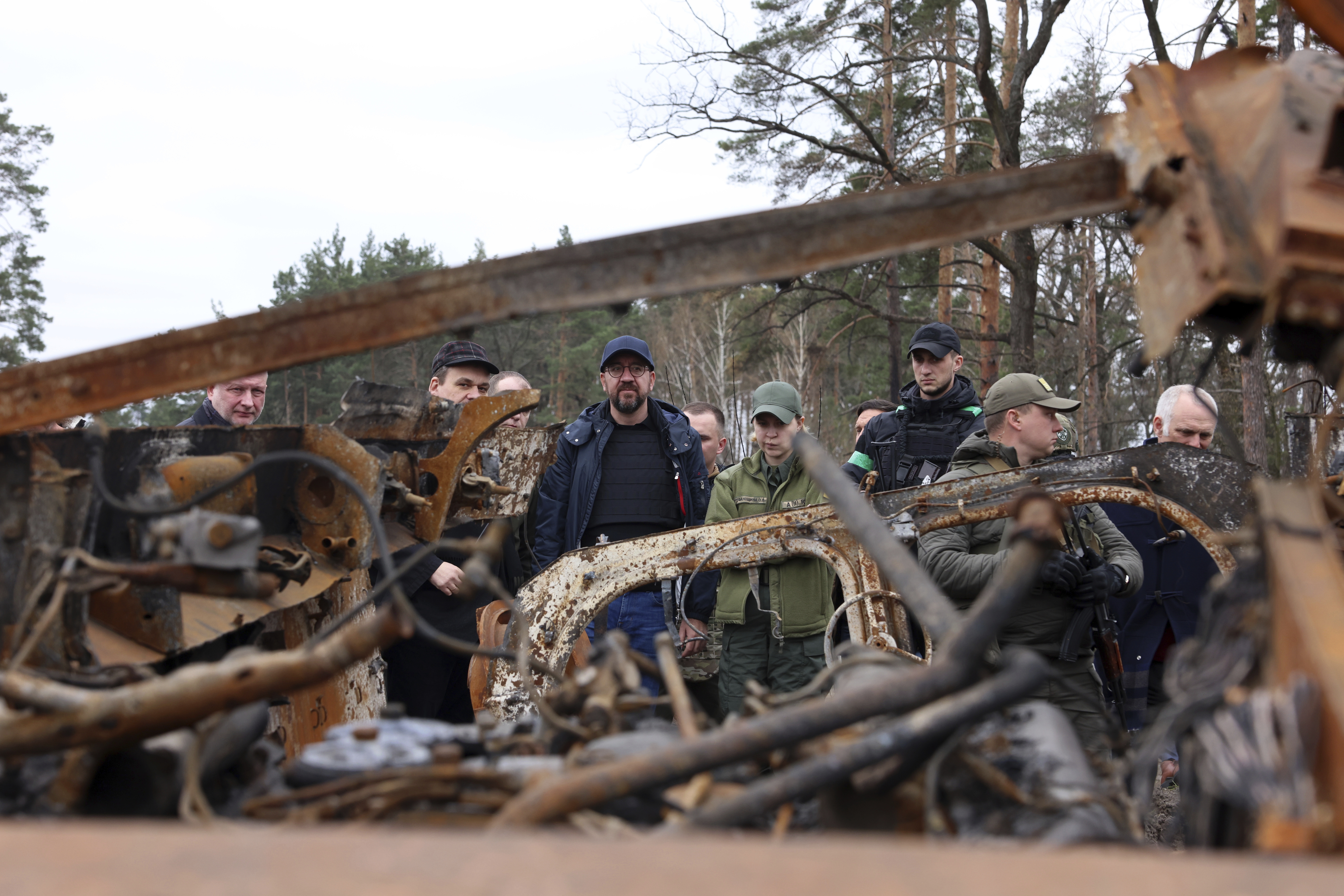 European Council President Charles Michel, center, looks at destroyed vehicles as he is given a tour of the region of Borodyanka, Ukraine, Wednesday.