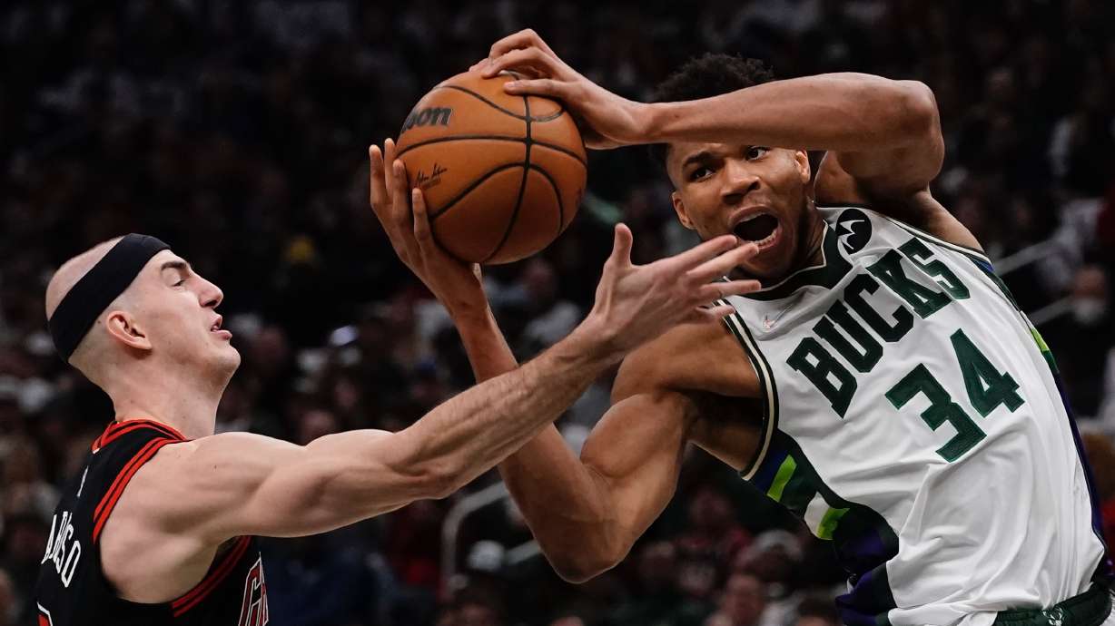 Milwaukee Bucks' Giannis Antetokounmpo and Chicago Bulls' Alex Caruso go for the ball during the first half of Game 2 of their an NBA playoff basketball game Wednesday, April 20, 2022, in Milwaukee .