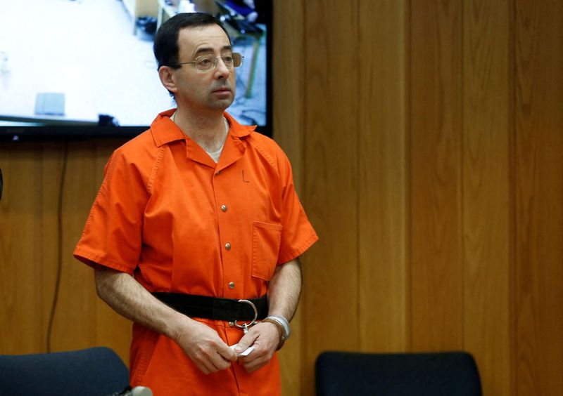 FILE PHOTO: Larry Nassar, a former team USA Gymnastics doctor who pleaded guilty in November 2017 to sexual assault charges, stands in court during his sentencing hearing in the Eaton County Court in Charlotte, Michigan, U.S., February 5, 2018.