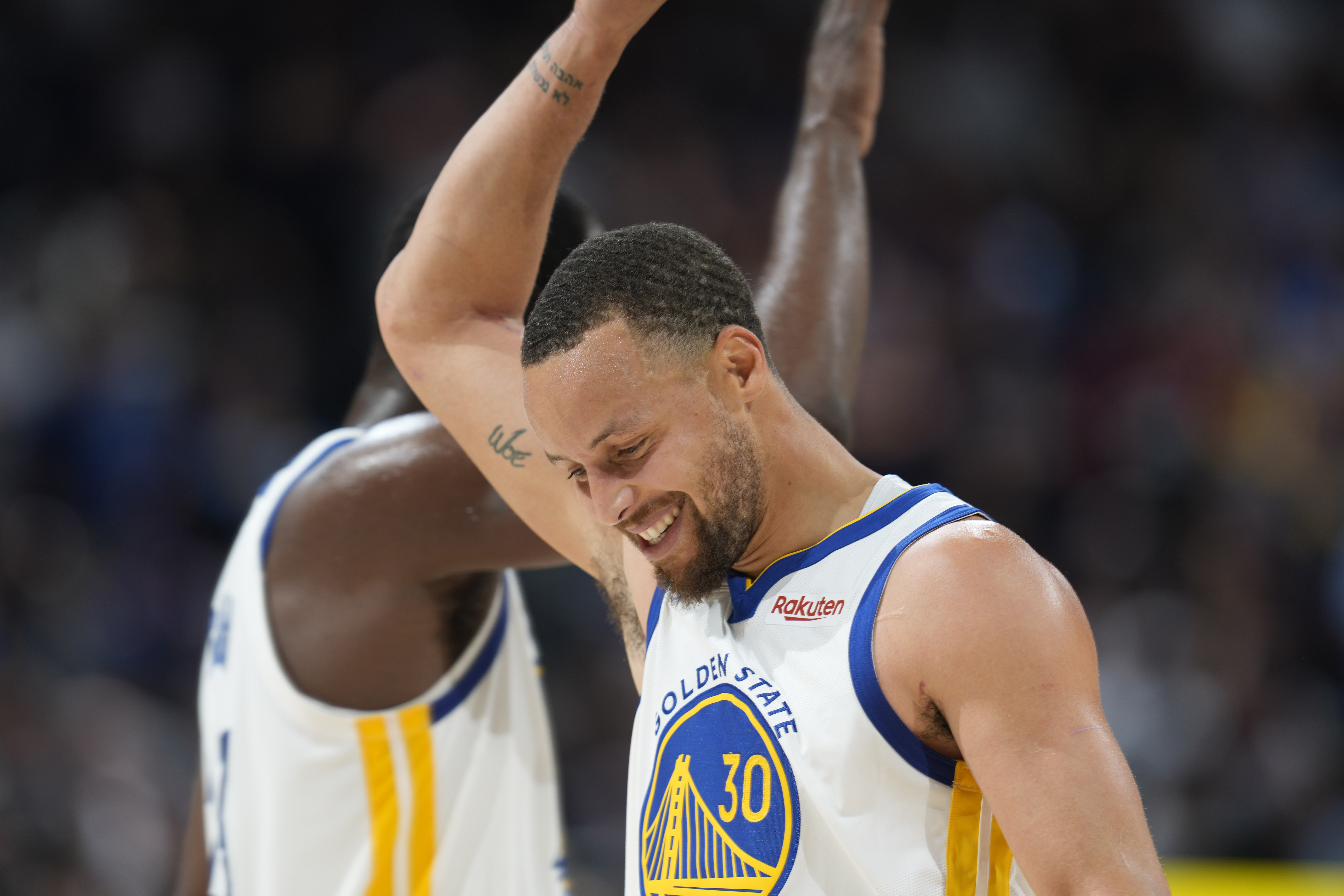 Golden State Warriors guard Stephen Curry, front, congratulates forward Draymond Green near the endoof Game 3 of the team's NBA basketball first-round Western Conference playoff series against the Denver Nuggets Thursday, April 21, 2022, in Denver. 