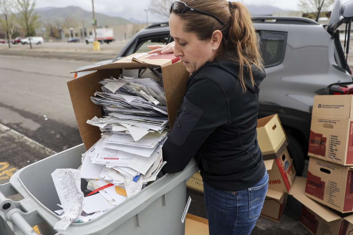 Alicia Larson throws away a box of papers for the free paper service at the annual Declutter Day at the University of Utah in Salt Lake City on Friday.
