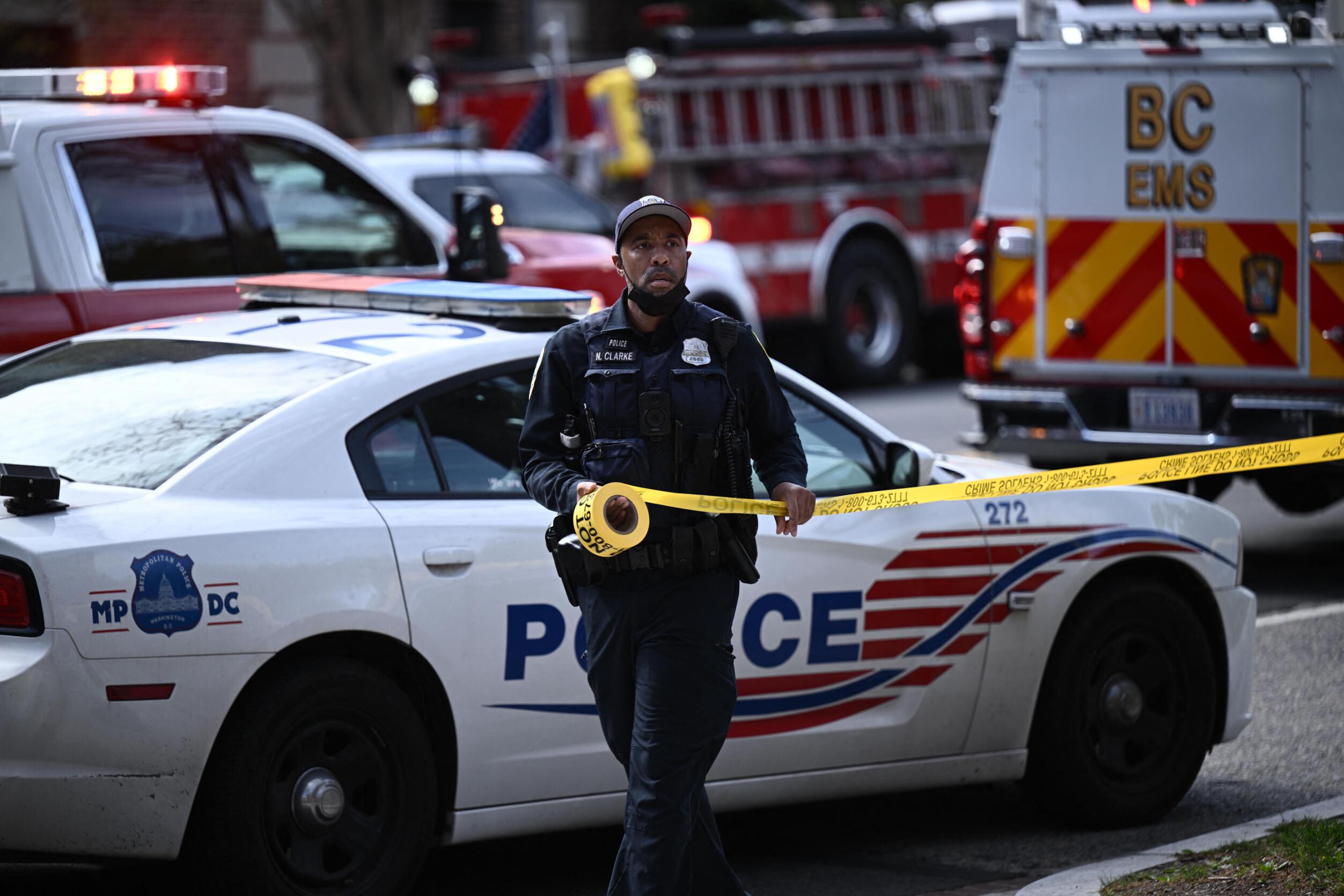 A police officer secures the area after a shooting Friday in northwest Washington, D.C.