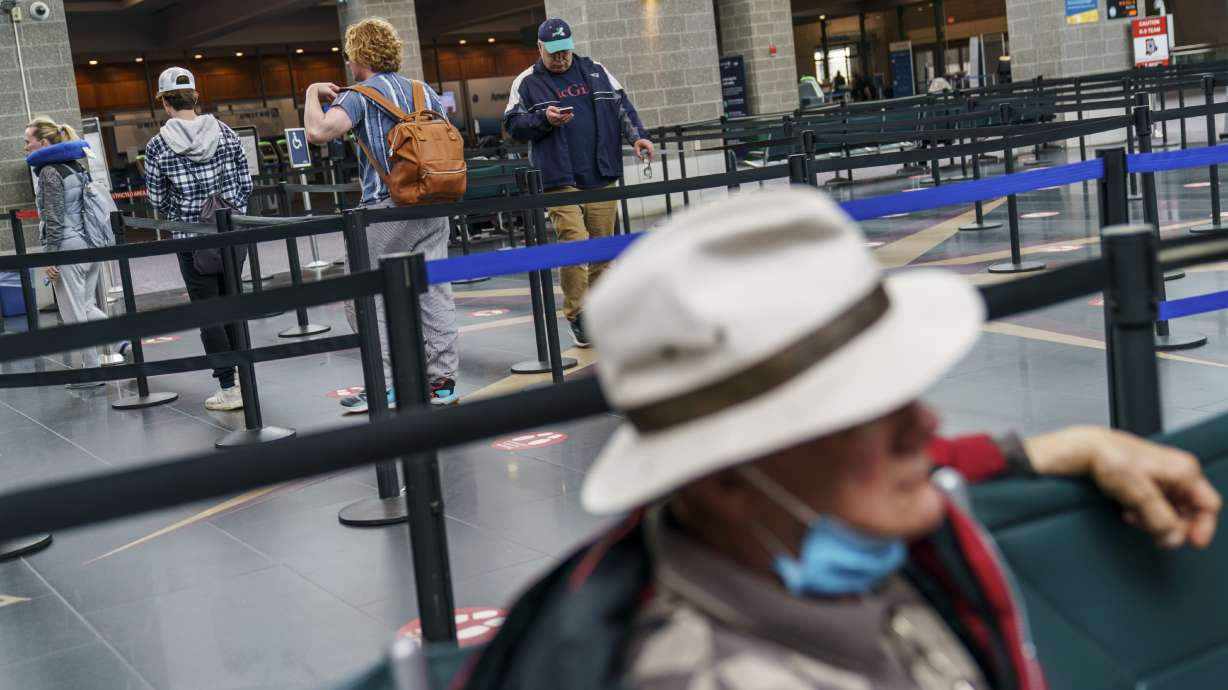 Travelers enter a security line at Rhode Island T.F. Green International Airport in Providence, R.I., Tuesday. A federal judge's decision to strike down a national mask mandate was met with cheers on some airplanes but also concern about whether it's really time to end one of the most visible vestiges of the COVID-19 pandemic.