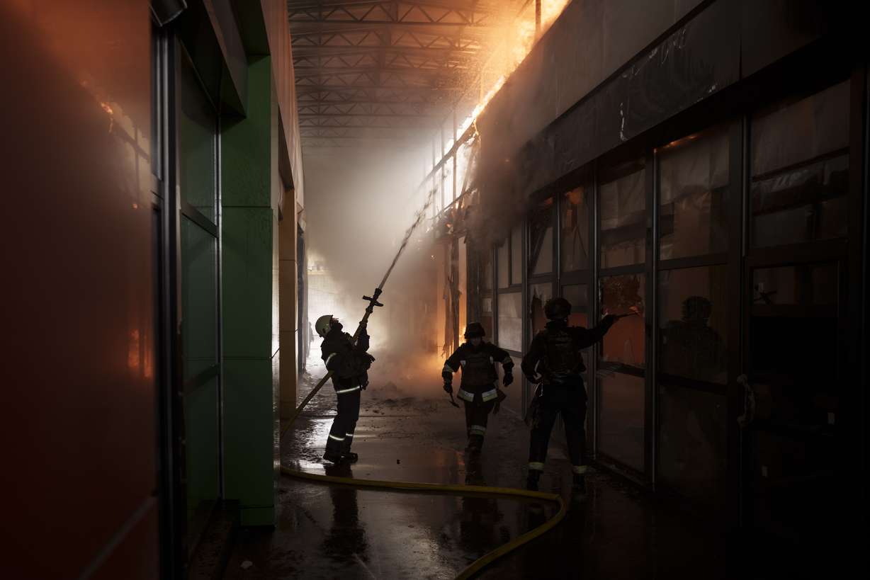 Firefighters work to extinguish a fire at a shop following a Russian bombardment in Kharkiv, Ukraine, Friday.