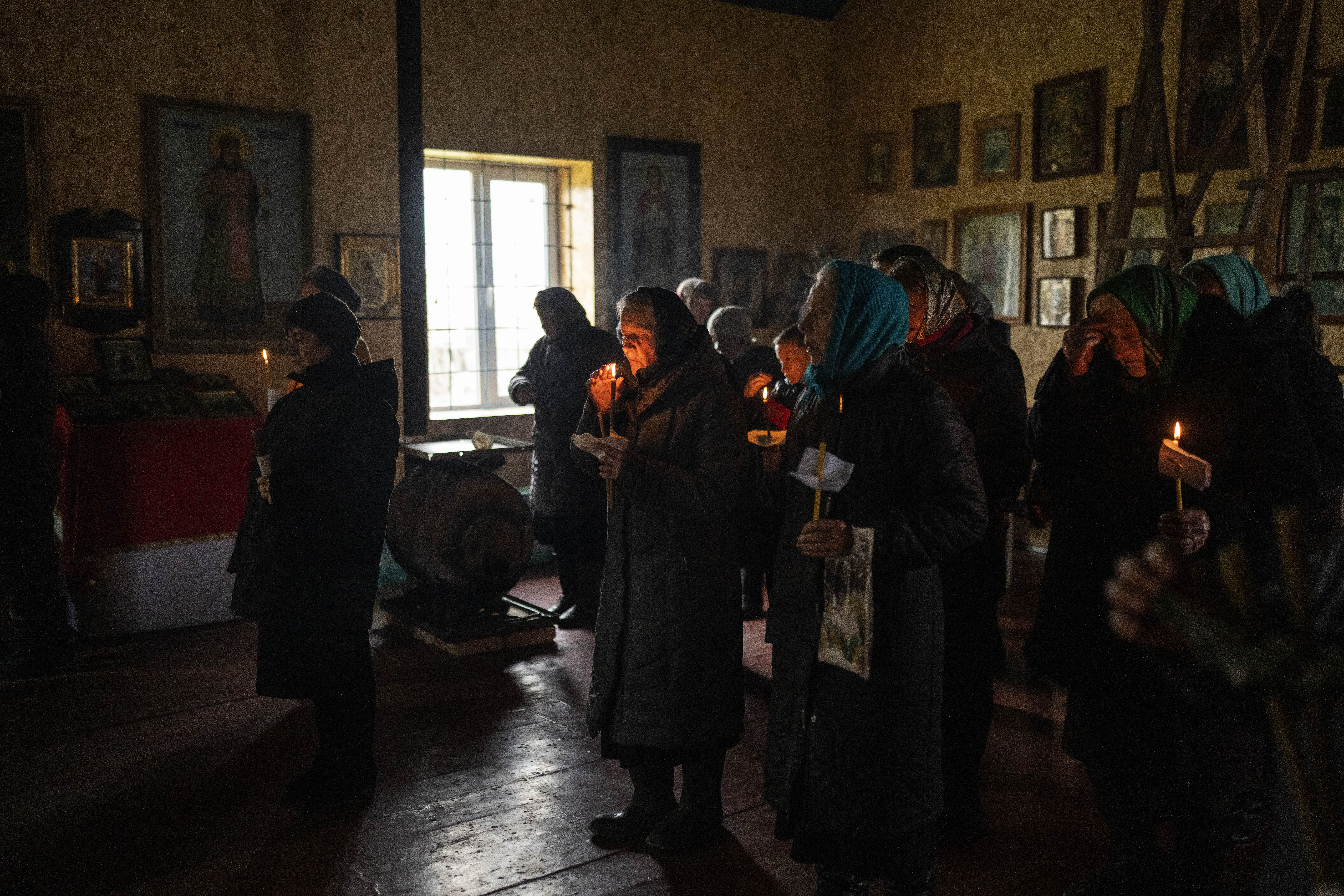 People attend a Good Friday ceremony inside the damaged Pokrova church, on the outskirt of Chernihiv, Ukraine, during Orthodox Easter, Friday.