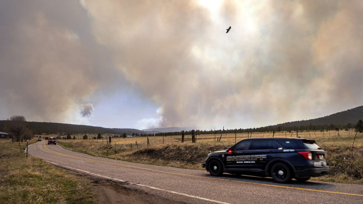 San Miguel County Sheriff's Officers patrol N.M. 94 near Penasco Blanco, N.M., as the Calf Fire burns near by Friday. Destructive Southwest fires have burned dozens of homes in northern Arizona and put numerous small villages in New Mexico in the path of danger, as wind-fueled flames chewed up wide swaths of tinder dry forest and grassland and towering plumes of smoke filled the sky.