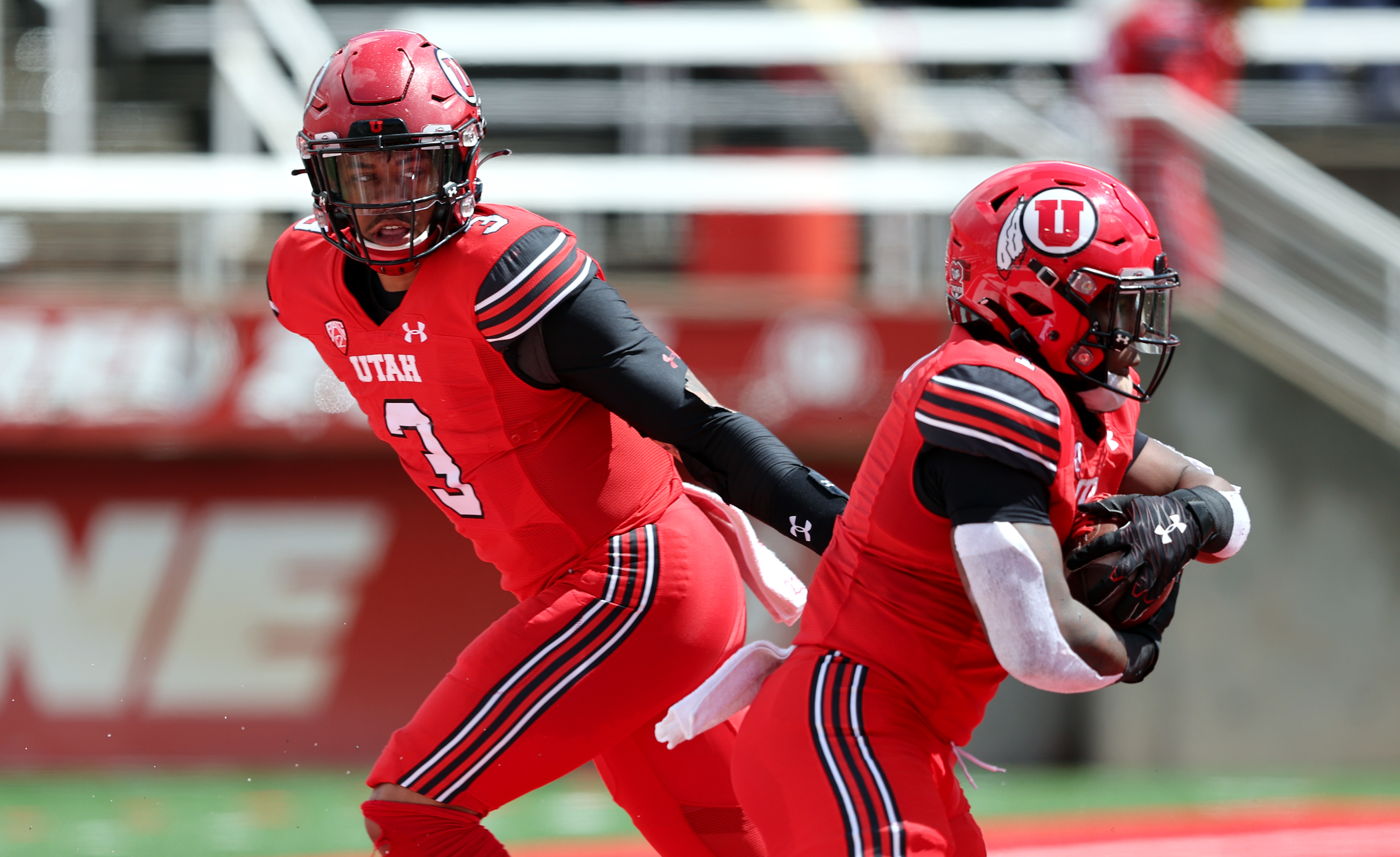 The Red team’s Ja’Quinden Jackson hands off to Jaylon Glover during the University of Utah's Red and White game at Rice Eccles Stadium in Salt Lake City on Saturday, April 23, 2022.