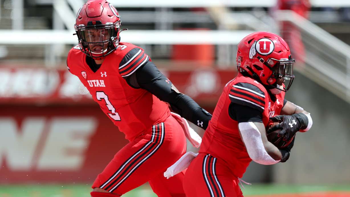 The Red team’s Ja’Quinden Jackson hands off to Jaylon Glover during the University of Utah's Red and White game at Rice Eccles Stadium in Salt Lake City on Saturday, April 23, 2022.